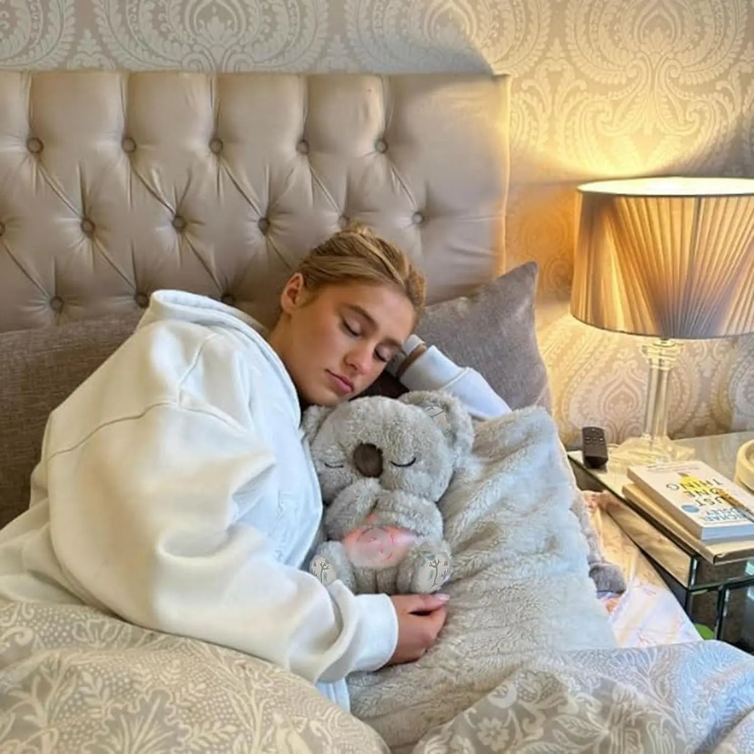 Woman sleeping in bed hugging a soft koala plush toy for comfort and better sleep