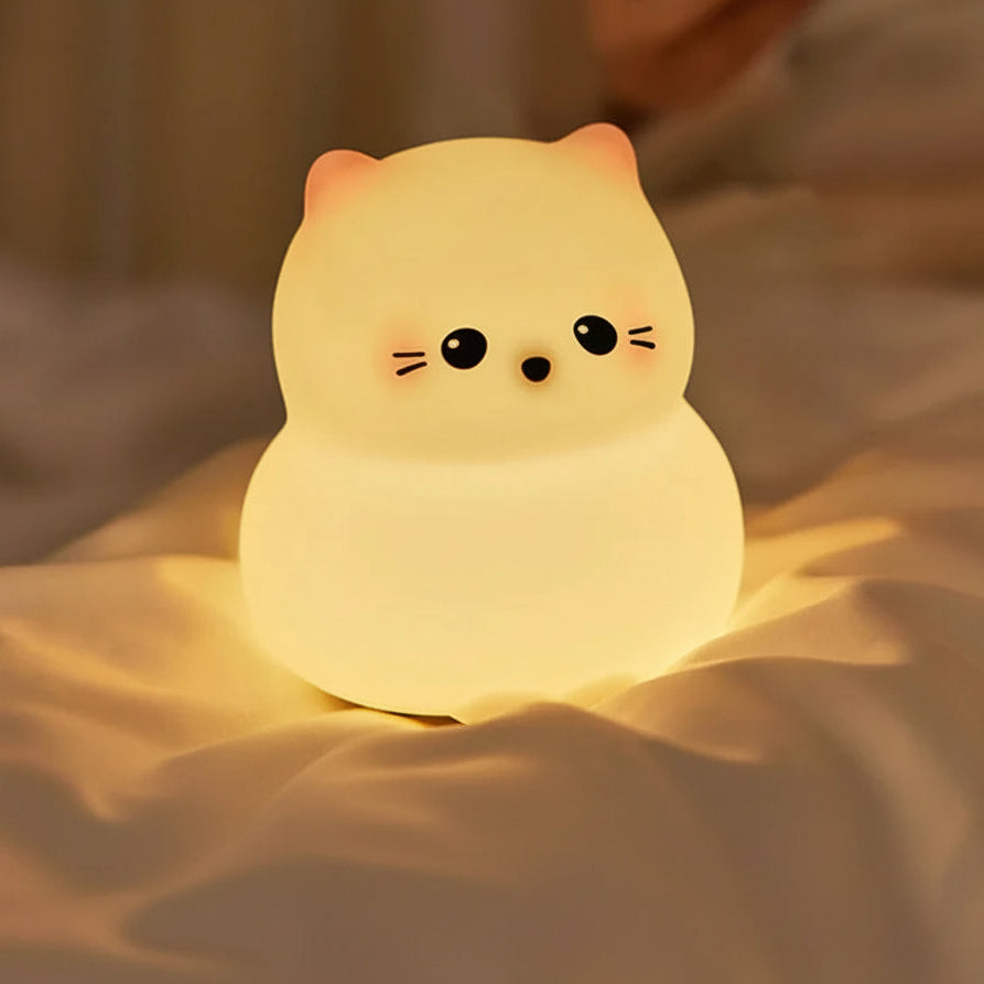 Soft glowing cat night light for kids on cozy bed, bedtime sleep support decor