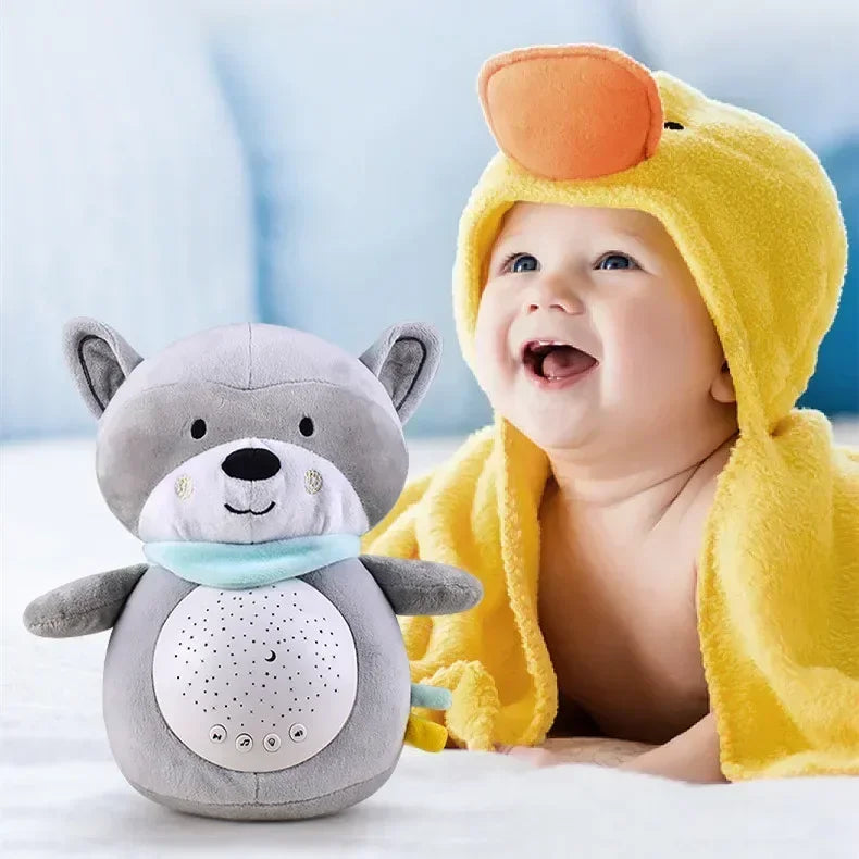 Smiling baby in yellow duck towel beside gray plush sleep soother with sound machine for babies